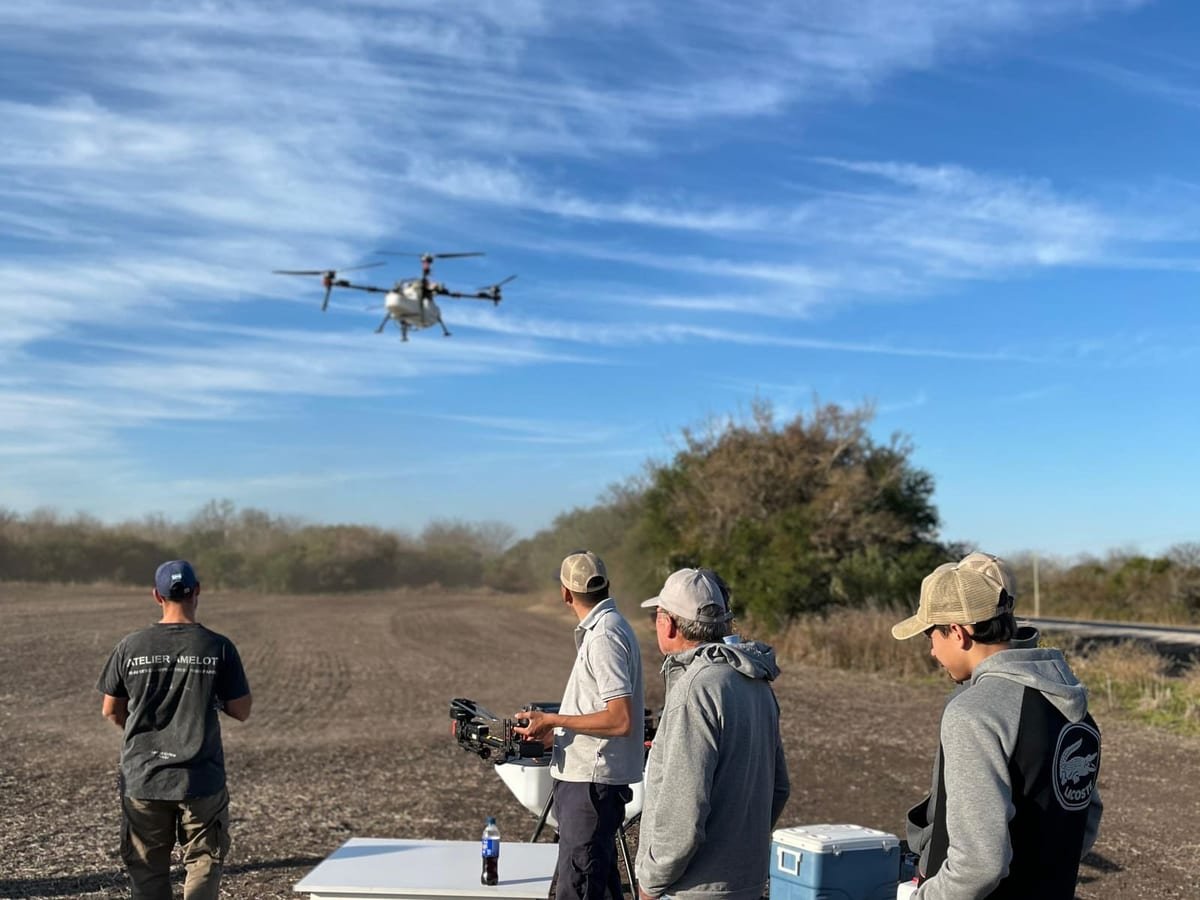Dron agrícola XAG en vuelo y operadores con el control remoto en un lote