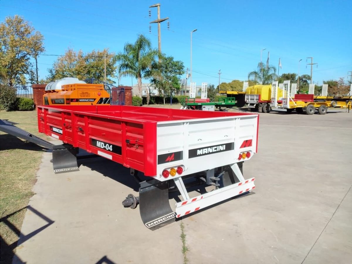 Acoplado playo rural Mancini MD-04 rojo con barandas, frente a la fábrica