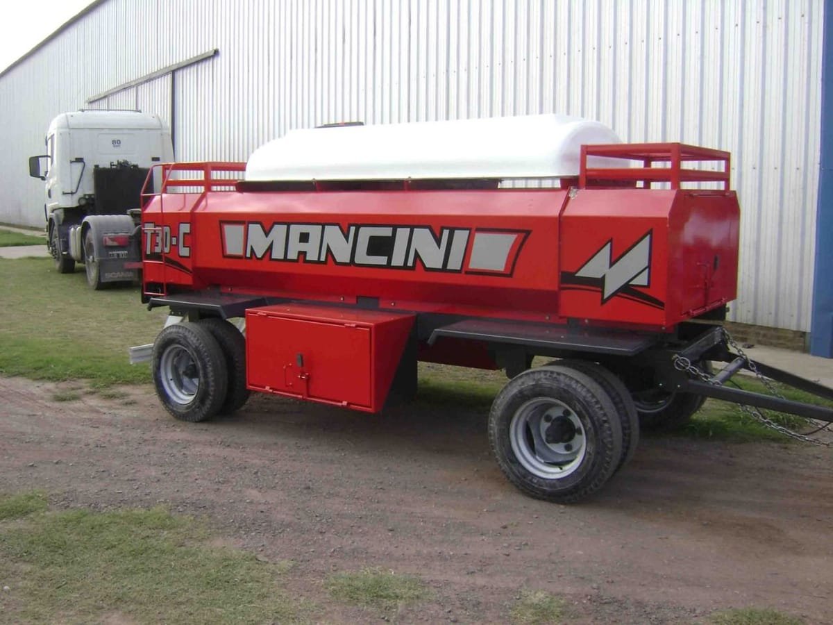 Acoplado tanque de combustible Mancini T-3000 rojo con depósito de agua arriba, frente a la fábrica