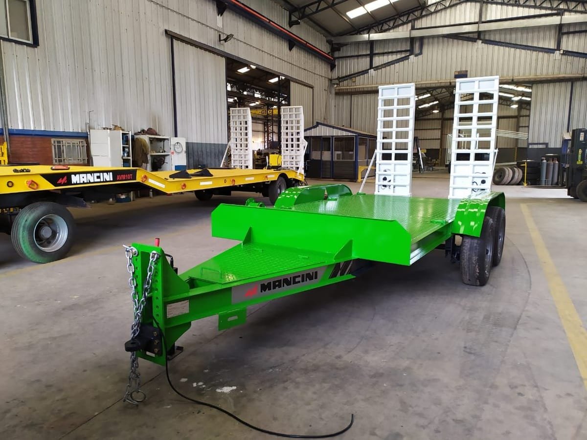 Carretón Mancini verde de dos ejes con rampas traseras levantadas, en la fábrica
