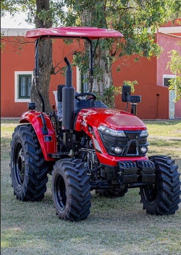 Tractor Traxor TRX 50 de frente y de costado, frente a una casa de campo
