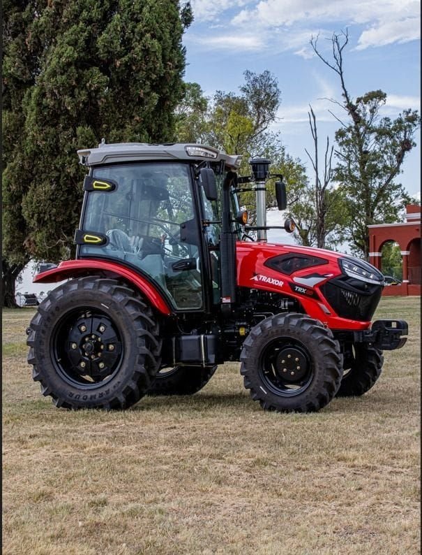 Tractor Traxor TRX 80 con cabina, de costado entre árboles