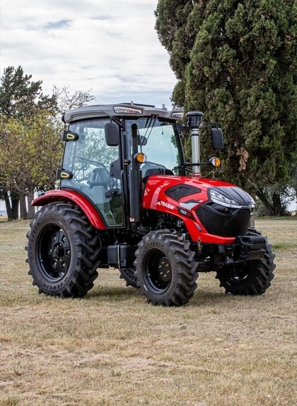 Tractor Traxor TRX 80 con cabina, de frente y de costado entre árboles