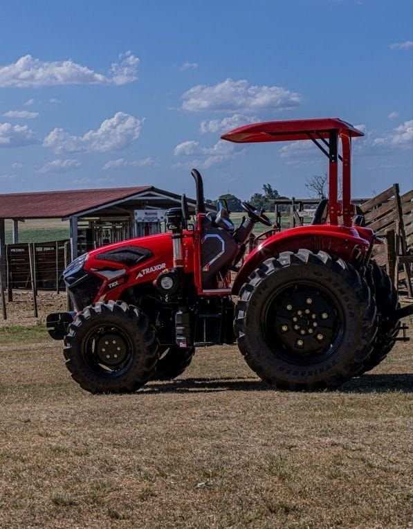 Tractor Traxor TRX 80 con techo, de costado junto a un corral